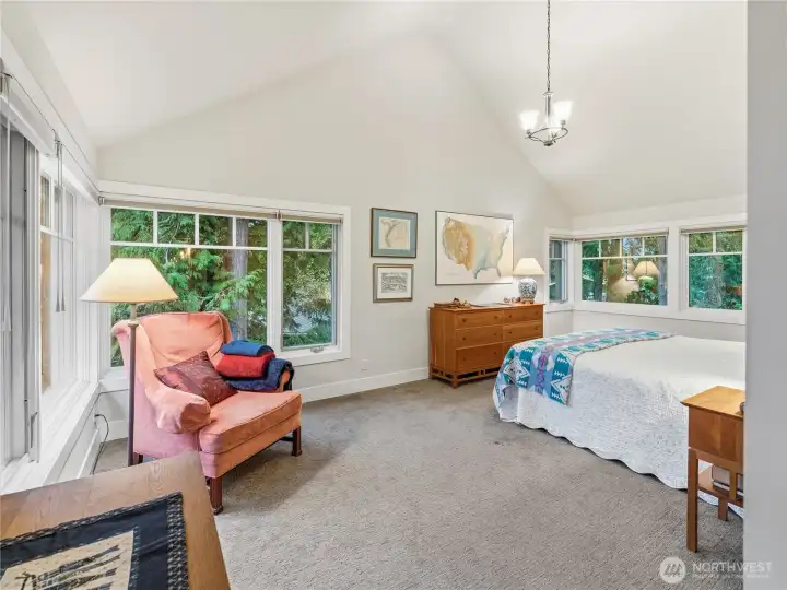 Huge primary bedroom with water and treetop views.