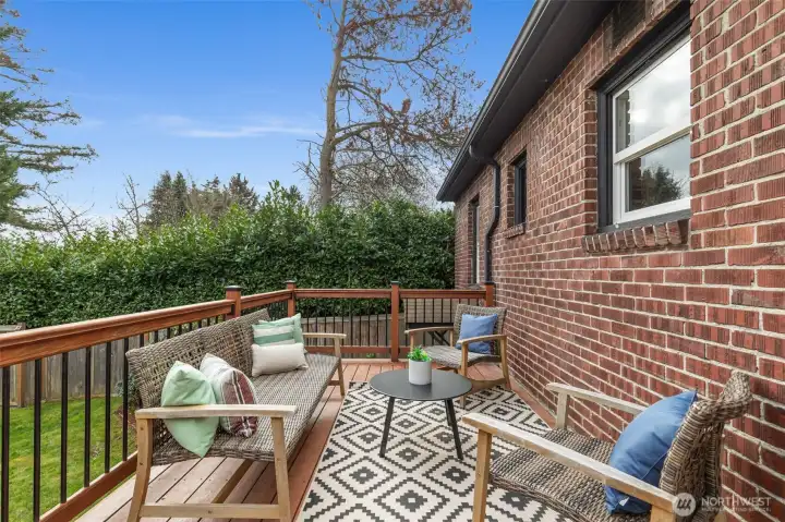 Elevated deck looking over fully-fenced lush green backyard.  Morning java?  Happy Hour?  Twilight al fresco dining?