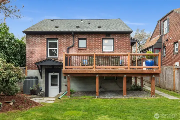 Elevated deck looking over fully-fenced lush green backyard.  Morning java?  Happy Hour?  Twilight al fresco dining?
