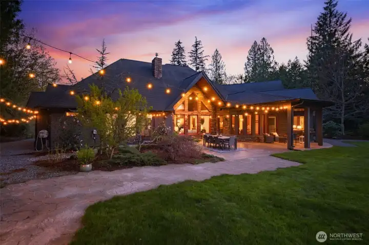 Back downstairs and outside, the expansive outdoor living area offers a perfect blend of covered and open-air spaces, the generous patio is anchored by beautiful, stamped concrete, ideal for dining and entertaining. Surrounded by natural beauty and framed by the home’s striking architecture, it’s designed for seamless indoor-outdoor living.