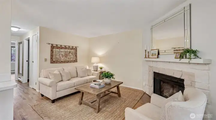 The cozy living room with wood-burning fireplace opens to the kitchen, dining room and balcony.