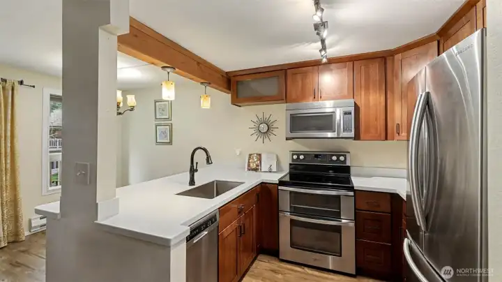 The kitchen opens to the living room and overlooks the dining area and balcony.