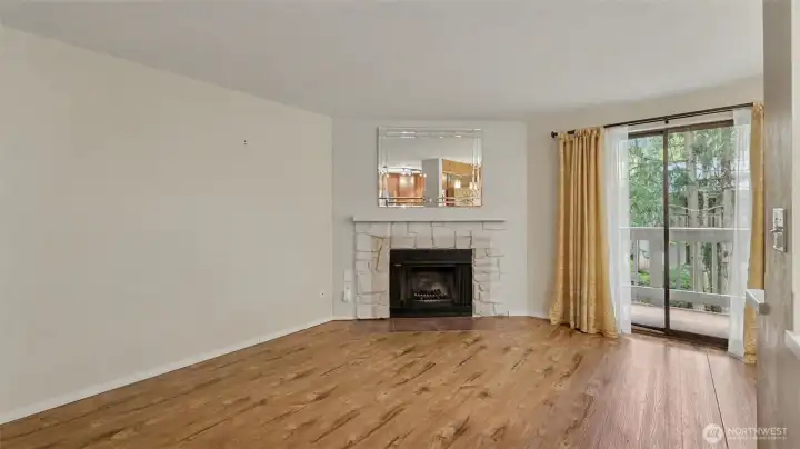 Living room with fireplace opens to the kitchen, dining area, and balcony.
