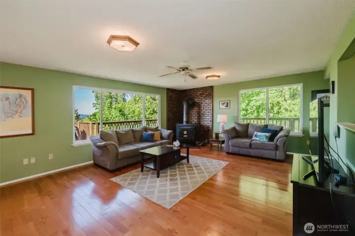 Living room with wood stove and gleaming hardwood floors