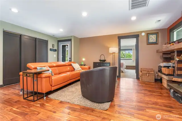 Spacious living room with view to primary bedroom, entry, and laundry behind 3 sliding doors.