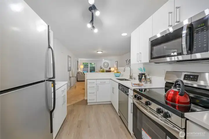 From the refrigerator vantage, the kitchen opens seamlessly to the main living areas, underscoring the efficient 930 SF layout and creating an easy flow for everyday living or entertaining guests.