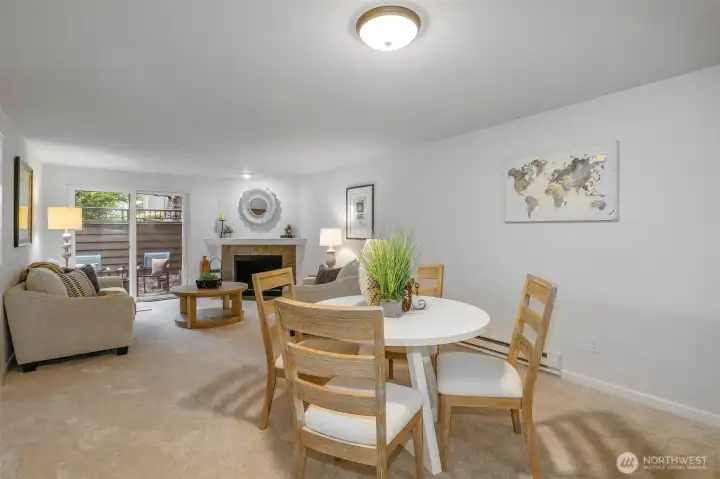 Here, the dining space flows effortlessly toward the patio and fireplace, illustrating how natural light and neutral tones enhance the home’s welcoming ambiance.