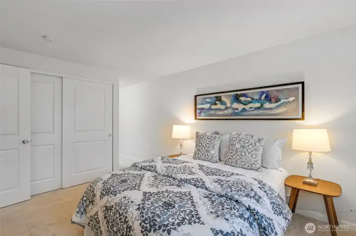 Primary bedroom features a wide double-door closet and direct access to the ensuite bath, all set on plush new carpet—creating a calm, organized retreat at day’s end.