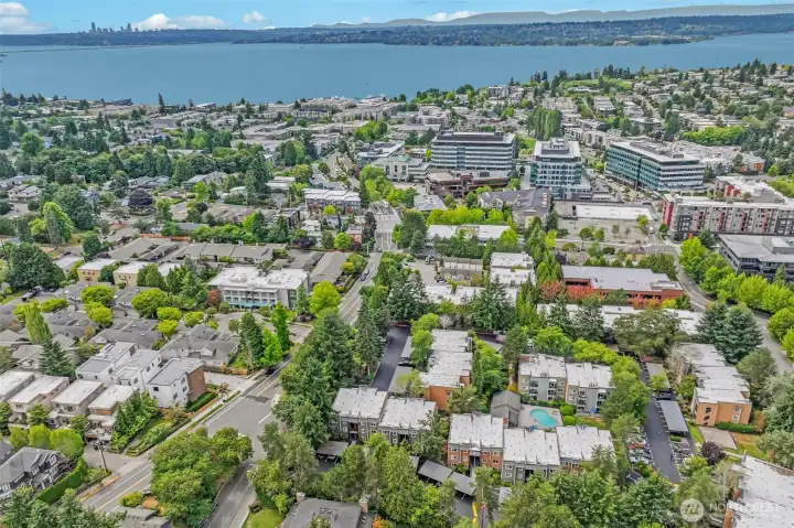 Aerial view places the community in Kirkland’s vibrant Downtown—just blocks to Google, Kirkland Urban, beach parks, and waterfront dining—with Seattle’s skyline visible across Lake Washington.