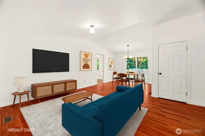 Living room (virtually staged), with dining area in the background. Sliding glass door leads to rear covered deck, and entrance to family room is also visible! Coat closet is to the right of the couch, easily accessible from front door.