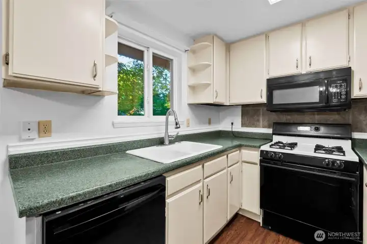 Cozy kitchen features tons of storage, a gas range, even a garbage disposal!