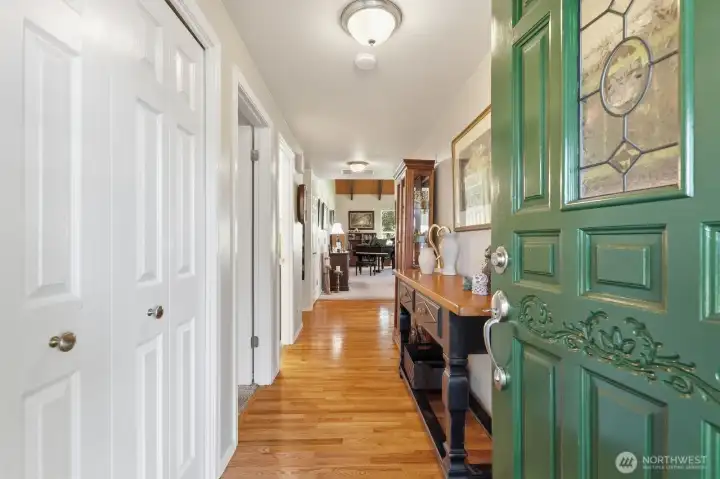 The bright, inviting front entry features rich hardwood floors that flow seamlessly into the main living areas.