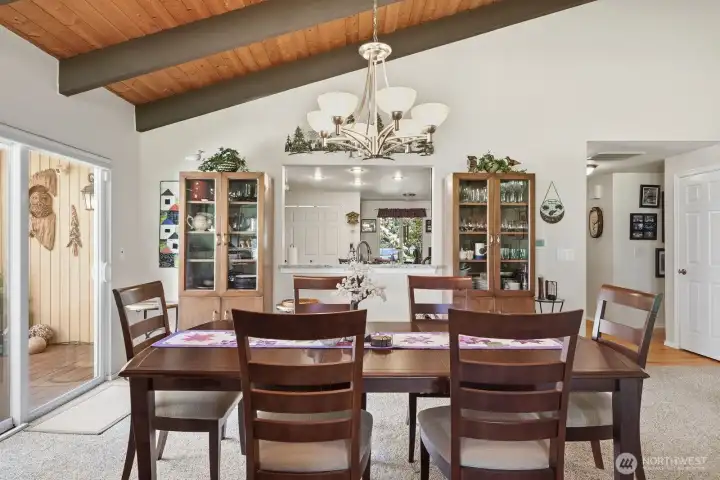 A dedicated dining area sits under the vaulted wood ceilings, offering a grand setting for dinner parties and holiday meals.