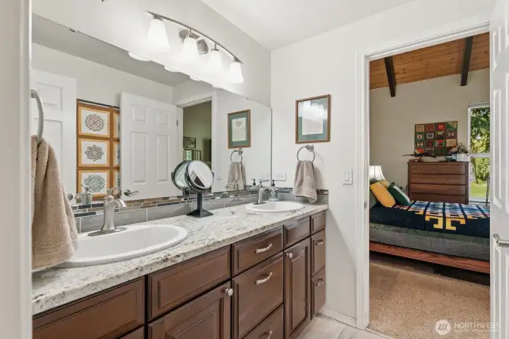 A beautifully updated private bathroom featuring a slab granite vanity and a modern walk-in shower.