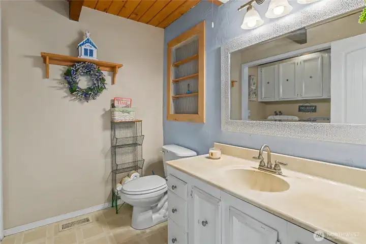 Bath with full size washer/dryer off eating area in kitchen.