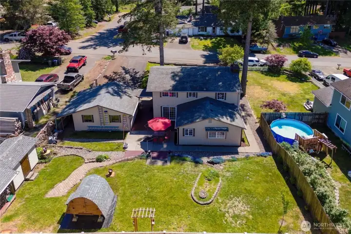 Drone photo from rear of home showcasing the backyard.