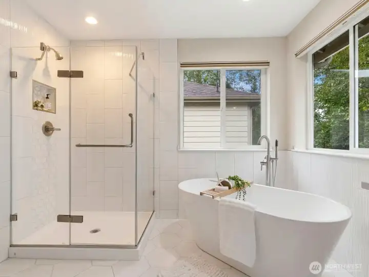 Spa-inspired primary ensuite bath featuring a soaking tub and glass-enclosed shower. Spa-inspired primary ensuite bath featuring a soaking tub and glass-enclosed shower.