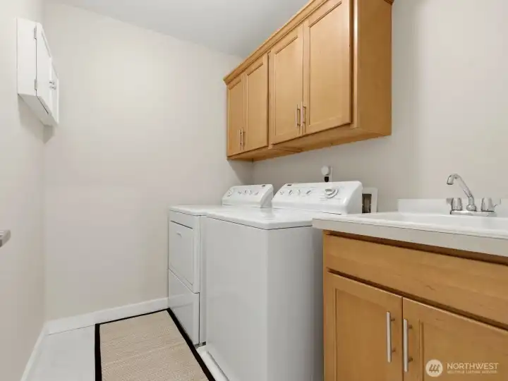 Located on the upper level, the well-designed laundry room with utility sink, storage, and workspace. Located on the upper level, the well-designed laundry room with utility sink, storage, and workspace.