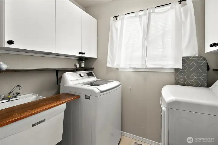Upper-level utility room with built-in storage solutions& adjoining linen cloest.