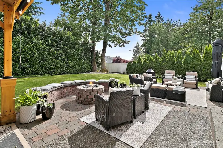 Resort inspired expansive patio space includes a cozy fire pit area with built-in seating.