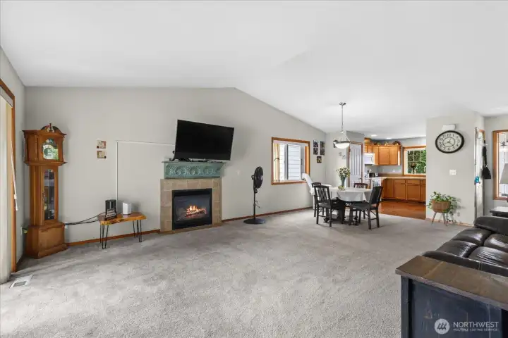 A view of the fireplace with the kitchen in the background.