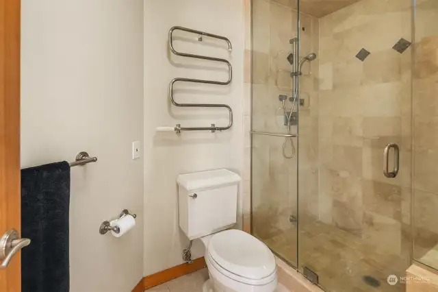 A walk-in steam shower with a heated towel rack in the primary bathroom.