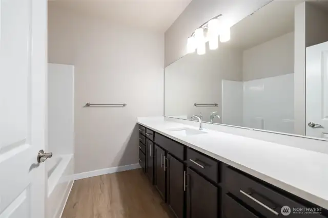 The main bath has a lot of counter space, taller cabinets and quartz countertops.