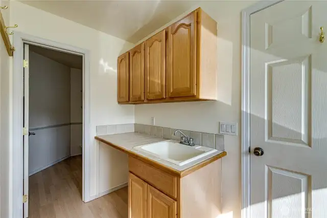 Spacious laundry area includes useful storage, work surface, utility sink plus a huge pantry closet.
