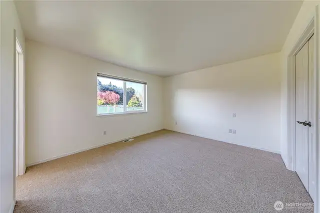 Primary bedroom with new carpet, offers views, walk-in closet and spacious bathroom.
