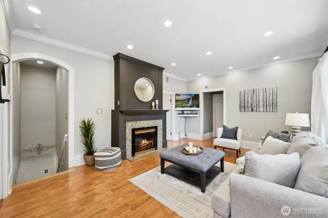 Inside, the light-filled living room includes the classic oversized millwork, and a cozy fireplace -- balancing sophistication and warmth, perfect for relaxed everyday living.
