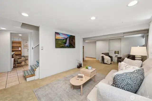 The basement has both interior access and it's own separate entry from the backyard. Looking through to the left is space currently utilized as workspace and to the right, the living space and hallway that lead to the third bedroom. It's the perfect hang-out space and great for chillin.