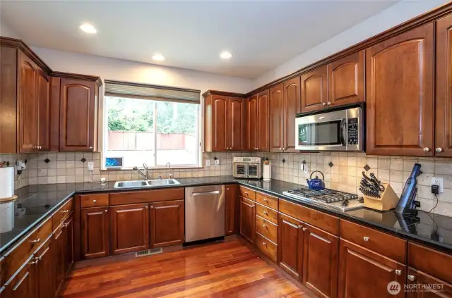 Enhanced with elegant Cherry cabinets and granite surfaces, the kitchen offers exceptional counter space and timeless appeal.