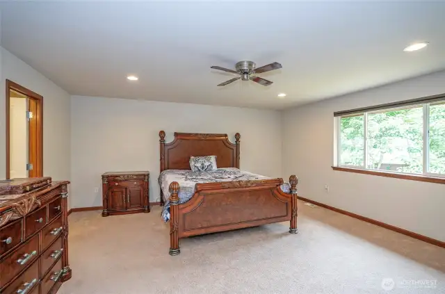 This additional view of the primary suite highlights its large windows, bringing in abundant natural light.