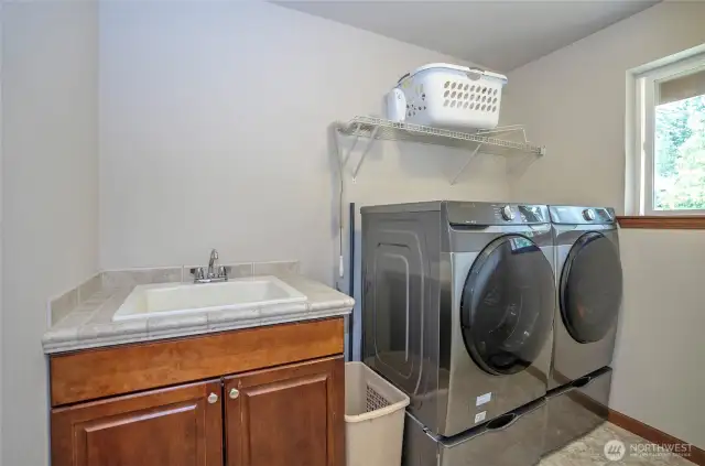 Smartly situated on the upper level, the utility room includes a useful sink and cabinetry for added functionality.
