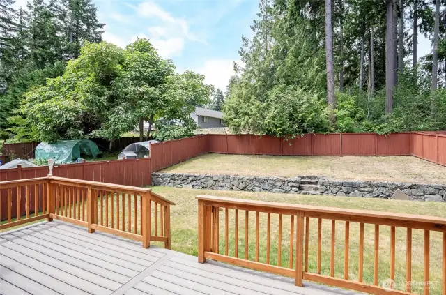 From the deck, take in the peaceful view of the fully fenced, tiered backyard—perfect for play, gardening, or relaxation.