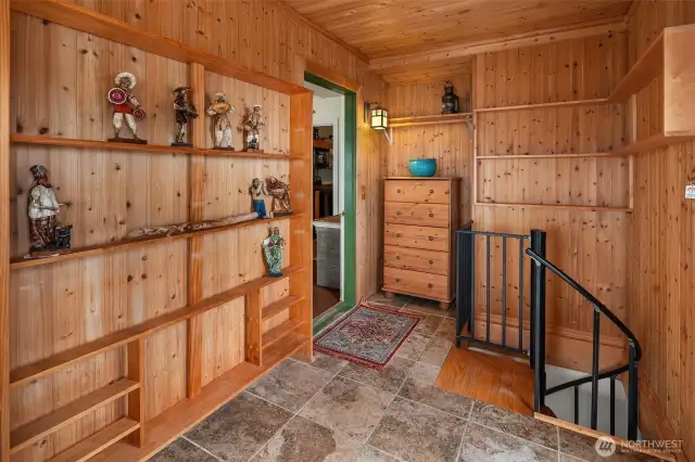 Built in shelves in the sunroom/mudroom, spiral stairs lead to lower level.