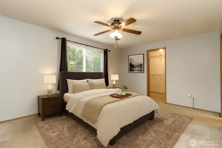Virtually staged primary with adjoining bathroom and walk in closet