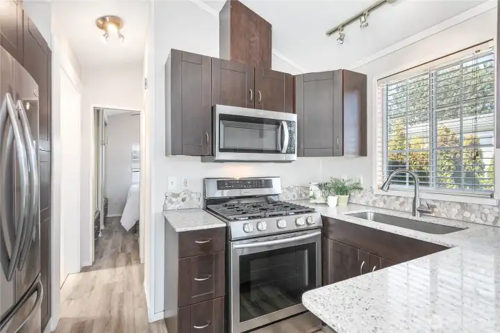 Kitchen was updated few years ago with solid surface counters, stainless steel appliances & nice tile backsplash.