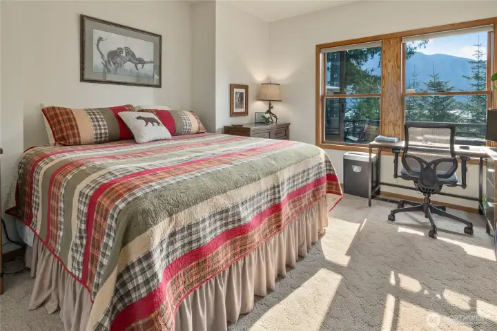 Large primary bedroom with lake and mountain views.