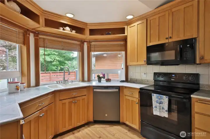 The bay window extends the kitchen into the lovely landscape.