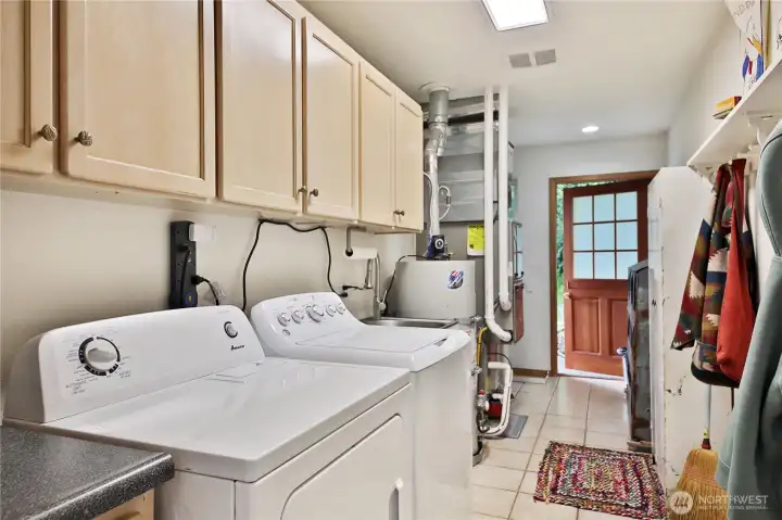 Large utility room with charming dutch door. The stairs to the finished attic storage are around the corner.