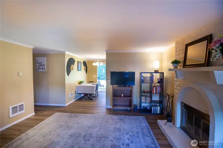 Again, looking from the living room through to the dining space and the slider to the covered patio and beautiful flowing river views.