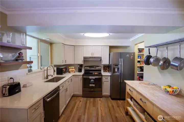 This updated kitchen is a dream for any chef, so light and bright and the beautiful LVP flooring is through out most of the rooms.  Newer soft close cabinets with tasteful functional planning and special pull-outs, and finished with beautiful quartz countertops.