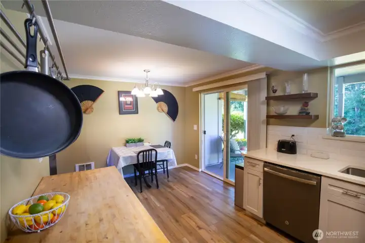 Looking from the pantry to the kitchen and dining area.  The slider leads out to the beautiful setting of the patio and river views beyond.