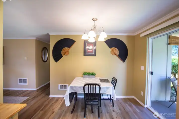 The dining area is located between the kitchen and living / great room, with a slider to the covered patio outside.