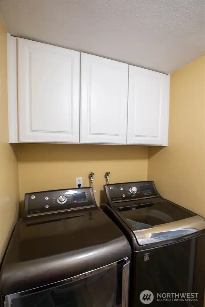 The laundry room has cabinets, washer and dryer stays, and the pass-thru door to the attached garage.