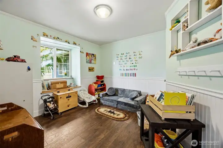 Light & bright front bedroom with wainscoting is currently being used as a play room for the littles.