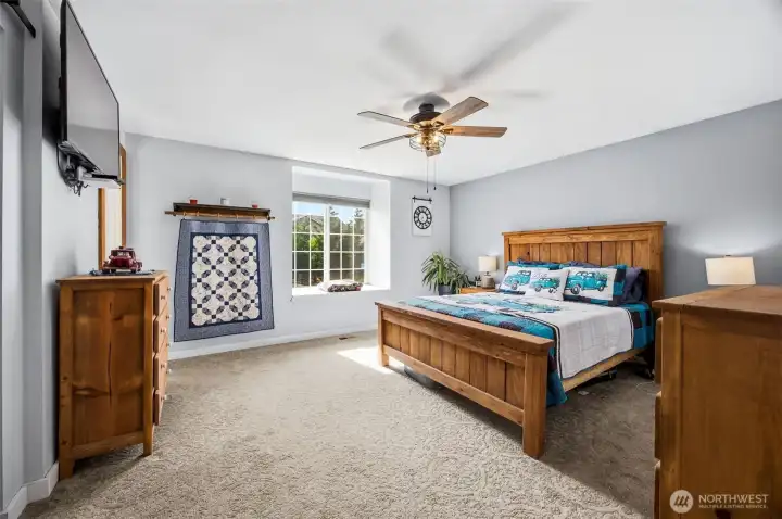 Primary bedroom is light and airy with a window seat.