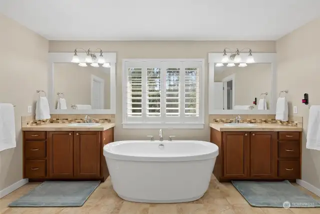 Separate vanities in this oversized en-suite with beautiful plantation shutters filtering the light.