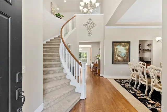 Elegance greets you with a sweeping staircase and vaulted ceilings as you enter .